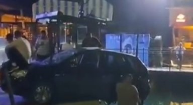 Askıda kalan otomobilin denize düşmemesi için kaputa oturup çekiciyi beklediler