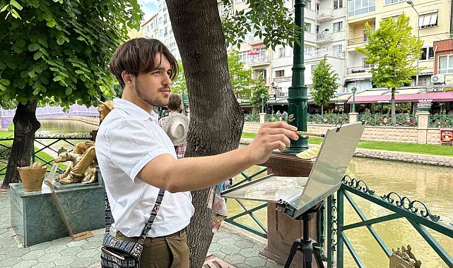 İlk kez geldiği şehrin sokaklarını gezerken sulu boya ile resmediyor